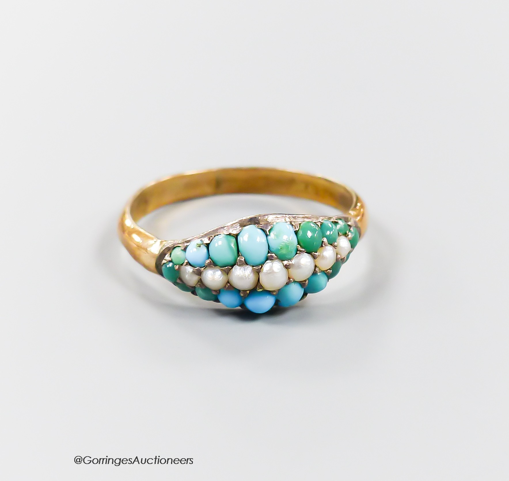 A yellow metal and graduated turquoise and seed pearl set three row half hoop ring, size R, gross 1.7 grams.